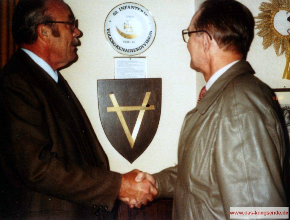 Im Haus Schlesien in Heisterbacherrott. Als Zeichen der Versöhnung reichen sich 1995 Johannes Baczewski und ein ehemaliger Sergeant der 78. US-ID die Hände. Im Hintergrund ein Teller mit Wappen der 62. ID/VGD.